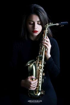 a woman holding a saxophone in front of her face