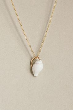 Petite white Nassa seashell, clutched by a 14k gold fill wire to make it a charm. Elegant Shell-shaped Rose Gold Jewelry, Elegant White Shell Pendant, Elegant Rose Gold Shell-shaped Jewelry, Everyday White Hand-wrapped Jewelry, White Shell Jewelry Gift, Dainty White Shell-shaped Necklace, White Shell-shaped Shell Jewelry, Dainty White Shell Necklace, White Shell Jewelry With Ocean-inspired Style