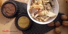 a bowl filled with food sitting on top of a table next to nuts and seeds