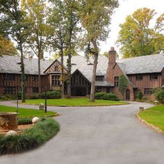 a large house with lots of windows and trees around it's front entrance area