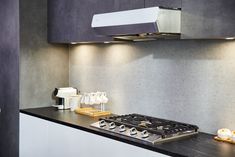 a stove top oven sitting inside of a kitchen next to a wall mounted range hood