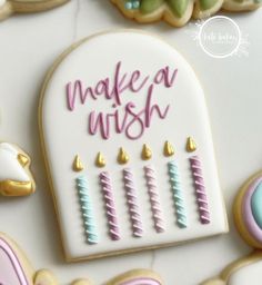 decorated cookies with the words make a wish written in frosting next to cookie decorations