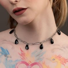 Elevate your elegance with the Gothic Teardrop Choker, a harmonious blend of mystery and sophistication. This striking piece features delicate black glass teardrop jewels, artfully suspended on a sleek silver coloured paperclip chain crafted from durable stainless steel. Designed in three sizes, it includes an optional 4-inch adjuster chain for the perfect fit. Whether you're dressing for a night out or adding a touch of drama to your daily fit, this choker promises to captivate. Presented in a Layering Earrings, O Ring Choker, Gothic Bracelet, Gothic Pendant, Choker Silver, Word Necklace, Gothic Chokers, Layered Chokers, Gothic Earrings