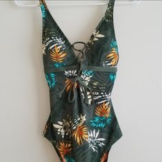 Moontide Women's One-Piece Swimsuit, Brand New With Tags Attached, Never Been Worn. Green And Orange Floral/ Palm Print, Lace Up Front And Tie In The Back. Padded/Lined Removable Cups. Adjustable Shoulder Straps. Hygienic Liner In Place. Usa Size 6. Designed In New Zealand. Make A Reasonable Offer On This Adorable Swimsuit!! Tropical Green One-piece Swimsuit, Green Tropical One-piece For The Beach, Green Tropical One-piece For Beach, Green One-piece Swimwear With Tropical Print, Green One-piece Beachy Swimwear, Green Tankini For Beach Party, Beachy Green One-piece Swimwear, Printed Green One-piece Swimsuit For Poolside, Green Summer Swimwear For Sunbathing