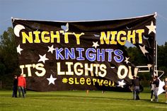 people standing in front of a banner that says nighty nights it's lights out