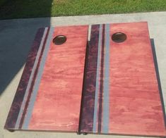 two red boards sitting on top of a cement floor next to grass and a sidewalk