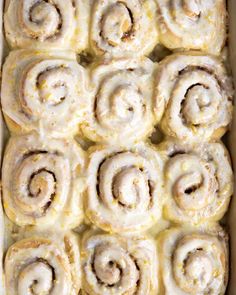 a pan filled with cinnamon rolls covered in icing