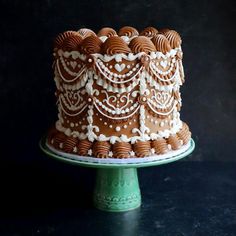 a chocolate cake with white frosting on a green plate and black background is shown