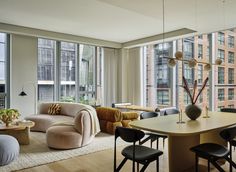 a living room filled with furniture and large windows