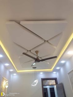 a ceiling fan with lights in the middle of a room that has white walls and ceilings