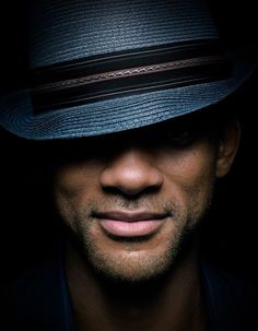 a close up of a person wearing a hat and looking at the camera with a serious look on his face