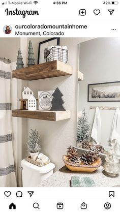 a bathroom decorated for christmas with pine cones and other holiday decorations on the shelf above the toilet