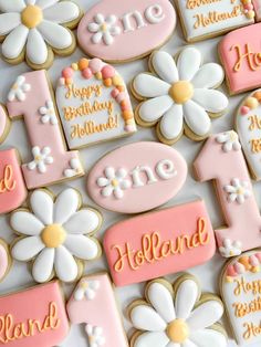 decorated cookies with flowers and the number one on them are shown in pink, yellow and white