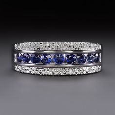 a blue and white diamond ring on a black surface with diamonds around the band, set in 18k white gold