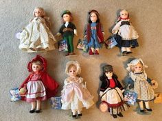 a group of dolls sitting on top of a carpet