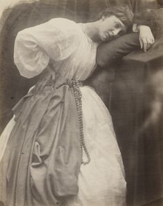 an old black and white photo of a woman leaning against a wall with her hand on her head