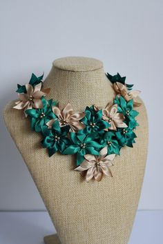 a green and gold flower necklace on a mannequin