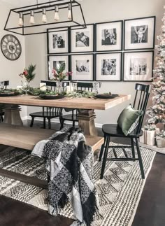 a dining room table with chairs and pictures on the wall above it, surrounded by christmas decorations