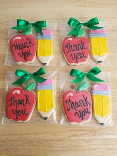 four decorated cookies in the shape of thank you teacher's day gifts on a wooden table