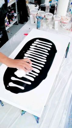 a person is working on a black and white art piece in the process of being painted