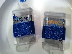 two plastic cups with blue glitter on them are sitting on a white plate, one has the word hanukka's written on it