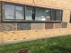 a brick building with two windows on the side and grass in front of it that has been taped off