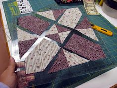 someone is cutting up the quilts on top of a table with scissors and other crafting supplies