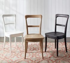 three chairs sitting on top of a rug in front of a white and black chair