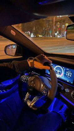 the interior of a car is lit up with blue lights and there is a steering wheel