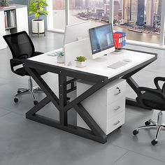 an office desk with two computer monitors on it and black chairs in front of the desk