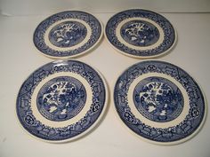 four blue and white plates sitting on top of a table