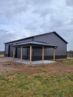 a large metal building sitting on top of a grass covered field