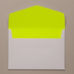 an envelope with yellow and white paper on the inside is open to reveal a blank note