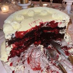 a large cake with white frosting and red toppings