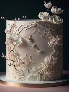 a white wedding cake with flowers on the top and an intricately decorated frosted design