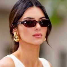 a woman wearing sunglasses and looking off to the side