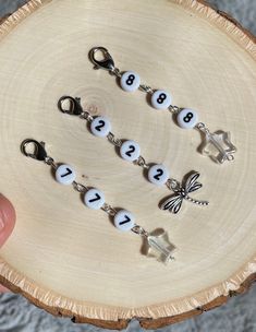 a hand holding a keychain with numbers on it and a butterfly in the middle