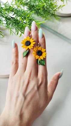 a woman's hand with two sunflowers on it