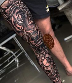 a man's leg with a tiger tattoo on it and a clock in the middle