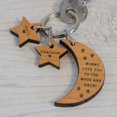 two wooden stars and a crescent shaped keychain with the words charlotte on it