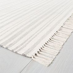 a white rug with fringes on the floor