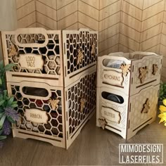 two wooden boxes sitting next to each other on top of a table with flowers in the background