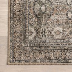 an antique rug on a wooden floor with white and brown accents, including a beige area rug