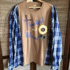 Upcycled oversized flannel tee, size L-2XL, light brown t-shirt with autumn sunflower graphic and words "Thankful and Blessed" combined with flannel sleeves of a light navy plaid fabric.  This reworked spliced shirt would make a great warm and comfy addition to your wardrobe this fall and winter! (WANT TO SEE MORE FROM THIS COLLECTION? Type RWTA in this store's search field.) These pieces are created to be an oversized fit. Please see measurements and approximate sizing below. DETAILS: APPROXIMATE SIZE:  L-2XL (depending on desired fit) Brands:  Sonoma Materials:  Cotton MEASUREMENTS: Top of shoulder to bottom hem:  28 inches Width across front at armpit:  30 inches This shirt is made from upcycled clothing, meaning previously owned/preloved.  Purchasing upcycled clothing is beneficial to Oversized Crew Neck Shirt For Fall, Oversized Flannel Tops For Fall, Fall Relaxed Fit Patchwork Shirt, Fall Cotton Shirt With Patchwork, Oversized Patchwork Shirt For Fall, Blue Oversized T-shirt For Fall, Oversized Graphic Print Shirt For Fall, Casual Plaid T-shirt For Fall, Fall Flannel Shirt With Graphic Print