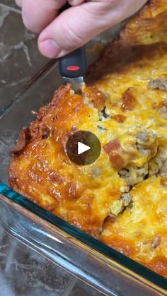 someone is using a knife to cut into a casserole in a glass dish