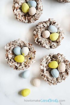 three bird's nest treats with candy eggs in them on a white table top