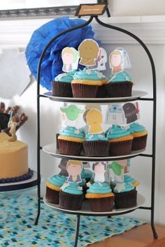 a three tiered cake stand with cupcakes on it