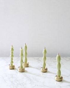 five candles are lined up on a marble table