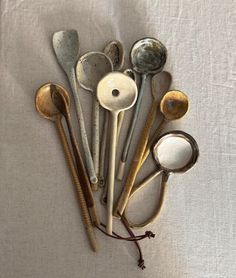 an assortment of spoons and ladles on a white cloth