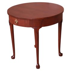 an oval wooden table with one drawer on the top and two legs at the bottom